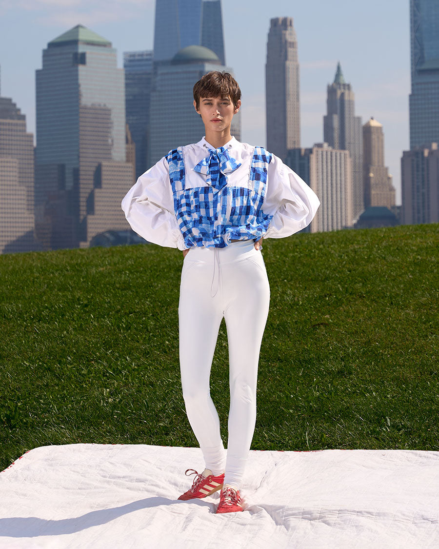 Brando Vassallo Editorial Fashion Lookbook Girl white leggings and oversized windbreaker blouse. city skyline in background